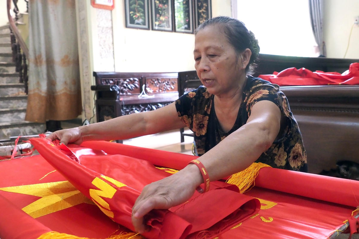 Bà Nguyễn Thị Thiết sau khi hoàn thiện lá cờ Tổ quốc.