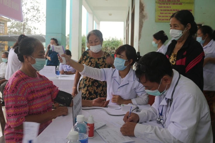 Cán bộ Y tế Trung tâm Kiểm soát bệnh tật tỉnh Quảng Bình khám, cấp thuốc cho người dân vùng lũ (Ảnh NH.V).