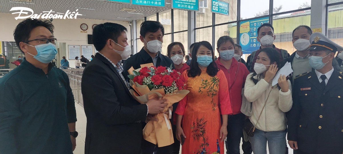 Lãnh đạo TP Móng Cái tặng hoa những người xuất cảnh qua cửa khẩu.