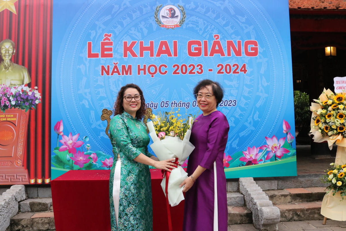 Đại diện phụ huynh học sinh nhà trường tặng hoa cho Ban Giám hiệu Trường THPT Đinh Tiên Hoàng.