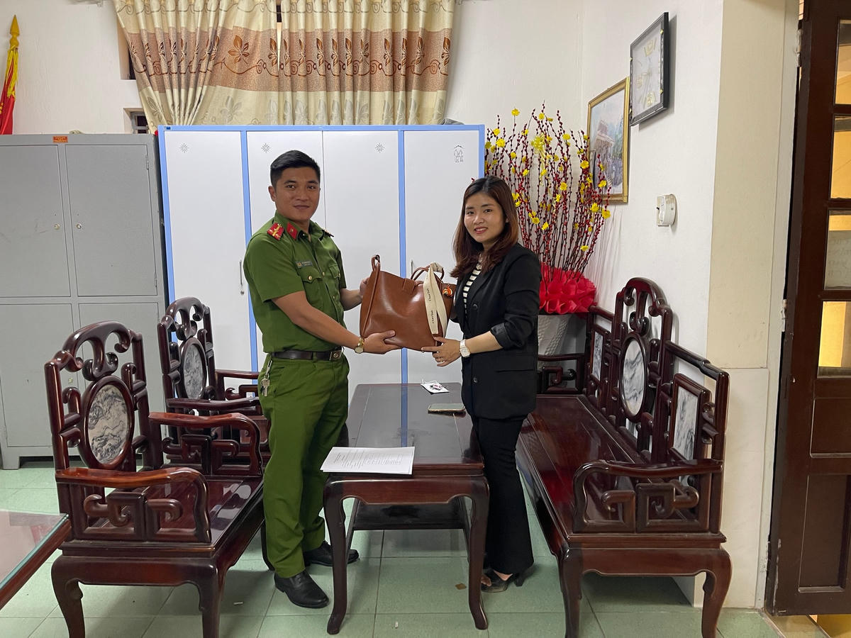 Chị Nguyễn Thị Ngọc vui mừng nhận lại chiếc túi xách của mình.