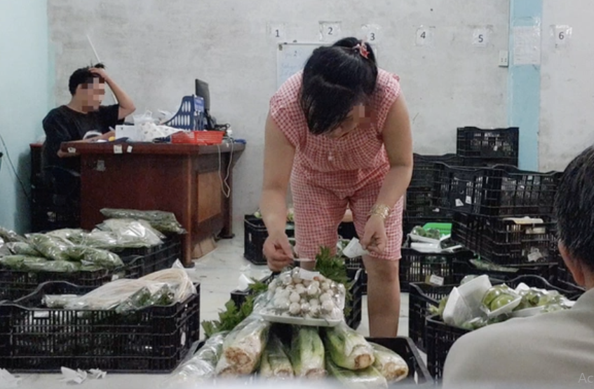 Công nhân dán tem VietGAP vào gói rau mua từ chợ đầu mối đã được sơ chế. Ảnh: Bông Mai/Tuổi Trẻ.