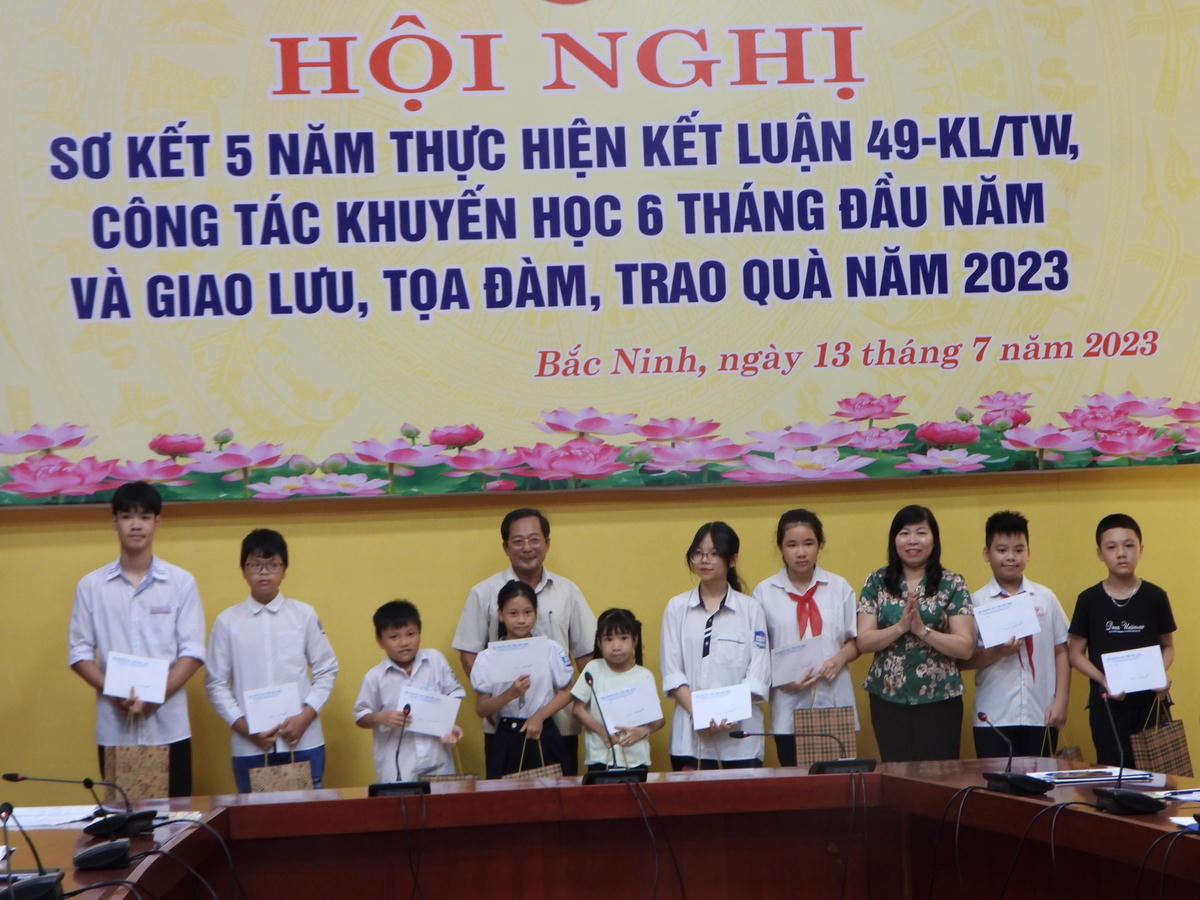 Đại diện lãnh đạo Hội Khuyến học tỉnh Bắc Ninh và Lãnh đạo Sở GD&ĐT tỉnh Bắc Ninh trao quà cho các em học sinh có hoàn cảnh khó khăn.