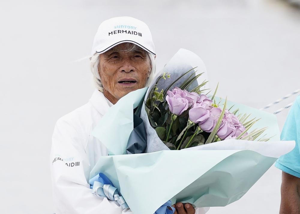 Kenichi Horie được tặng những bó hoa hồng. Ảnh: AP.