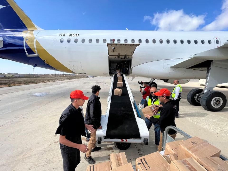 Các thành viên của Hiệp hội Nhà trọ Thanh niên Libya dỡ hàng viện trợ y tế đến bằng máy bay tại sân bay al Abraq, Libya, ngày 12/9/2023. Ảnh: Reuters.