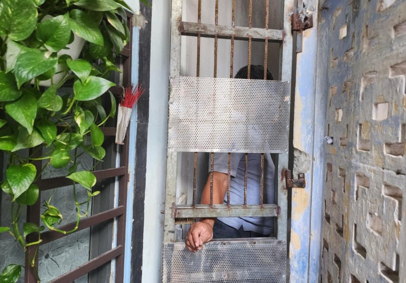 Con nghiện nhận ma túy qua khe cửa căn nhà nằm sâu trong kiệt 572 đường Ông Ích Khiêm. Ảnh: Công an Đà Nẵng.