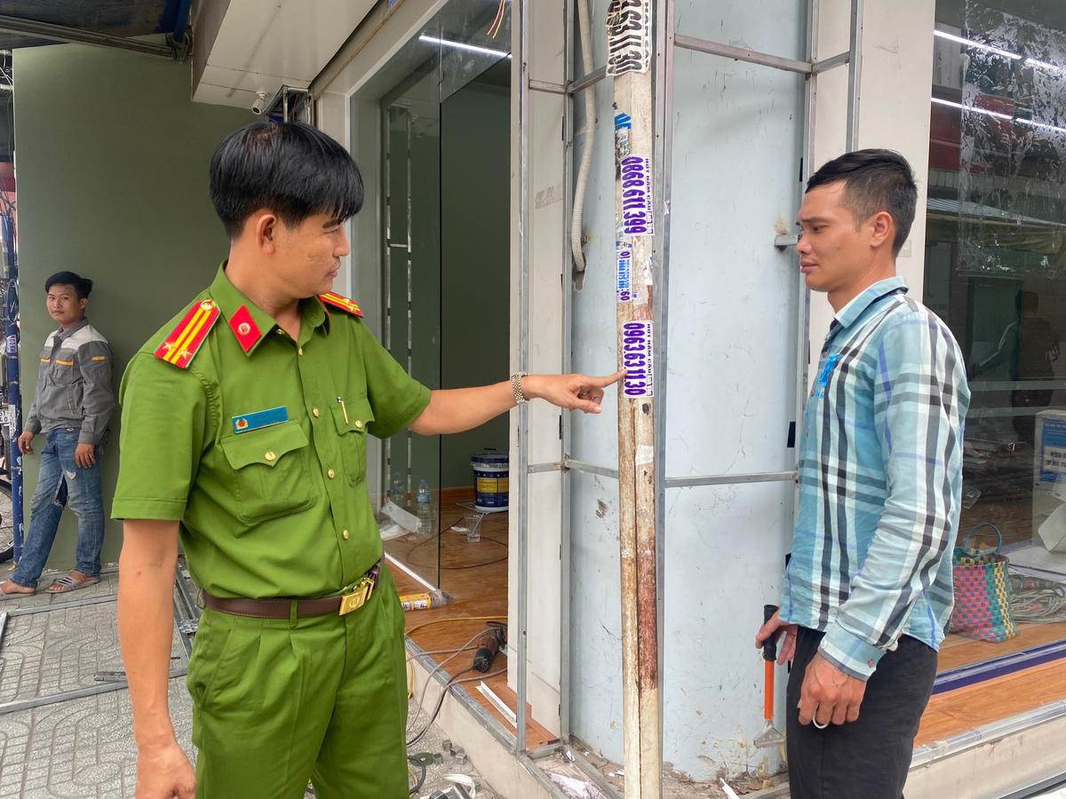 Đối tượng quảng cáo bẩn được công an đưa trở lại nơi đã vẽ bậy, dán quảng cáo để tự tay bóc gỡ, xóa vết bẩn do mình gây ra.