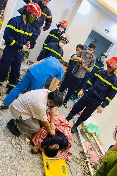 Lực lượng cứu hộ cứu nạn một nạn nhân tại hiện trường vụ rơi thang máy.