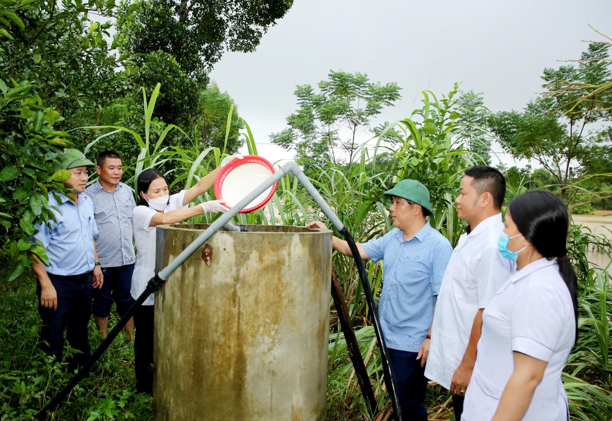 Cán bộ CDC Hà Tĩnh cùng với Trung tâm Y tế huyện Hương Khê hướng dẫn người dân pha Cloramin B để xử lý môi trường.