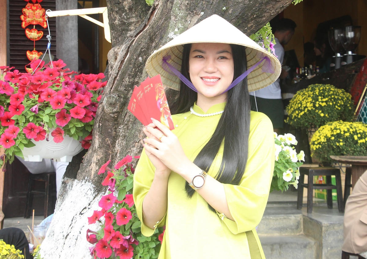 Một bạn trẻ chụp ảnh lưu niệm bên ngôi nhà cổ Hội An.