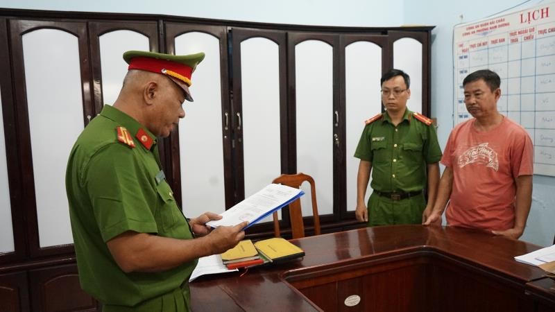 Nguyễn Nho Cầm (áo đỏ) nghe công an đọc lệnh bắt. Ảnh: Công an Đà Nẵng.