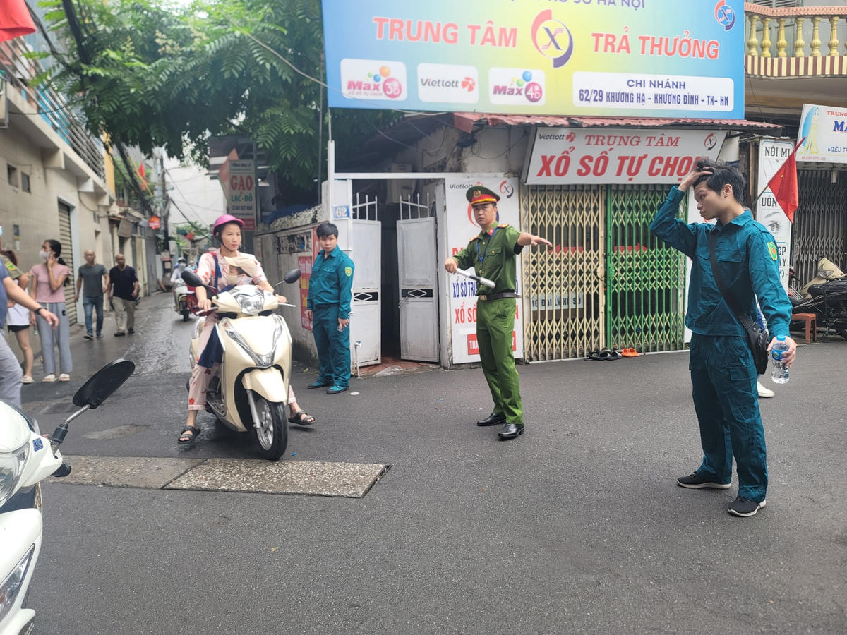 Lực lượng chức năng hướng dẫn người dân đi đường tránh hiện trường vụ cháy.