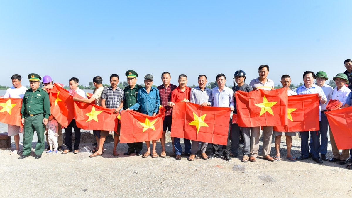 Đại diện Sở NNPTNT trao 10.000 lá cờ đến tay ngư dân địa phương.