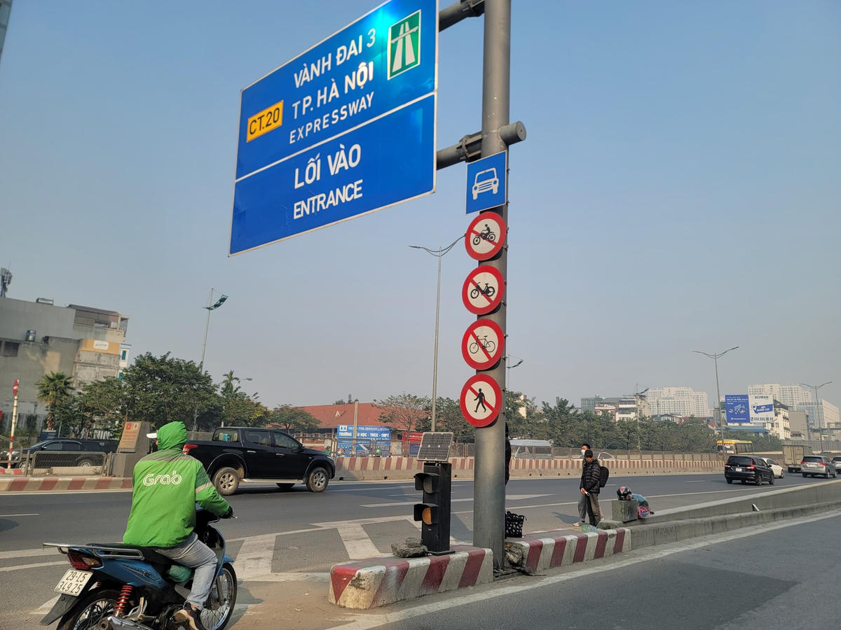 Cách đấy không xa, tại đoạn đầu đường Phạm Văn Đồng (đoạn trước cổng trường Đại học Ngoại ngữ, lối vào đường Vành đai 3 trên cao) nạn bắt khách diễn ra nhộn nhịp không kém. Khách đứng chờ xe ở lối vào Vành đai 3 trên cao.