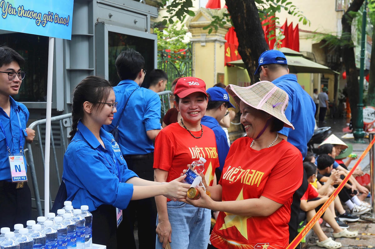 Lực lượng tình nguyện viên tại 48 Tràng Thi (phường Hoàn Kiếm, Hà Nội) hỗ trợ nước uống cho người dân đến theo dõi sự kiện A80. Ảnh: Tiến Đạt.