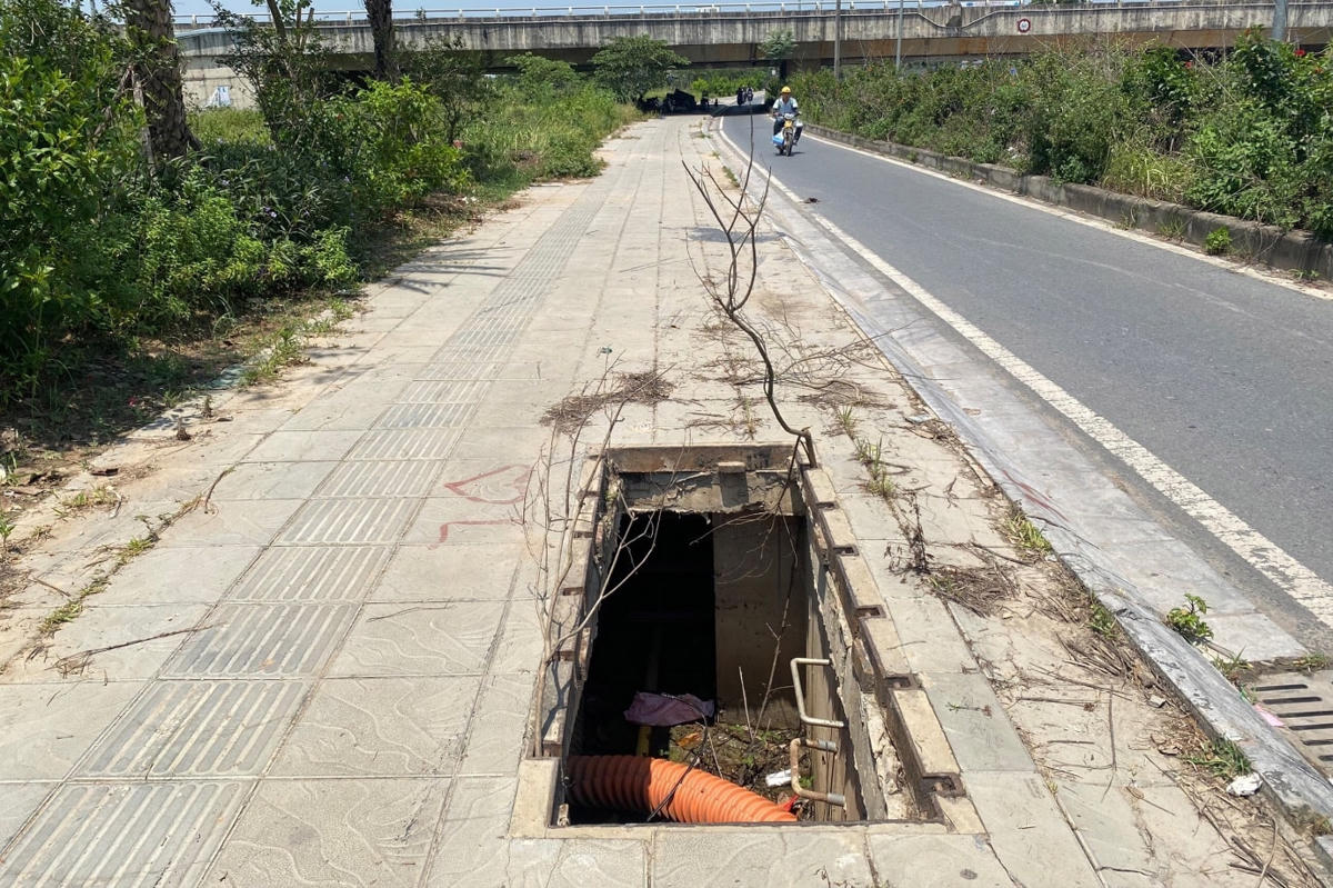 Cách đó không xa, hố ga với phần miệng bị bật tung lên. Lộ ra phần nắp “gai góc” như đang “giăng bẫy” người dân.