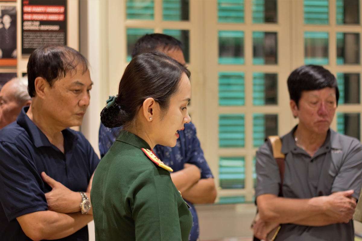 Hướng dẫn viên thuyết minh về các hiện vật trưng bày cho đoàn khách tham quan.