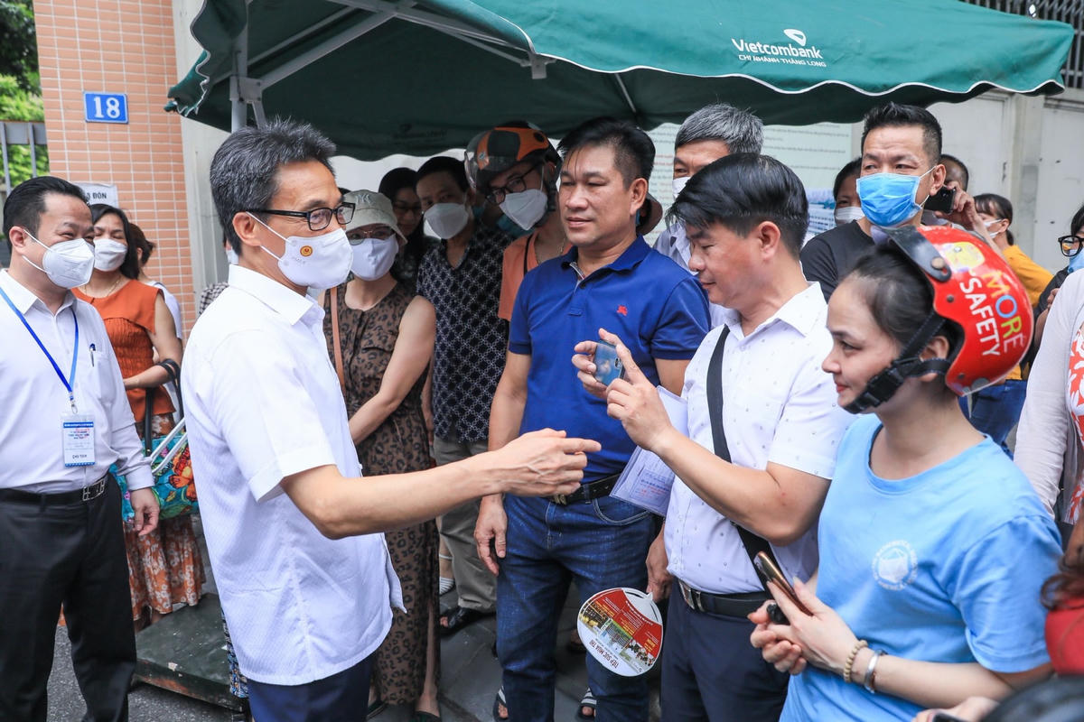 Phó Thủ tướng Vũ Đức Đam trò chuyện với các bậc phụ huynh đang nóng lòng chờ con trước cổng điểm thi.