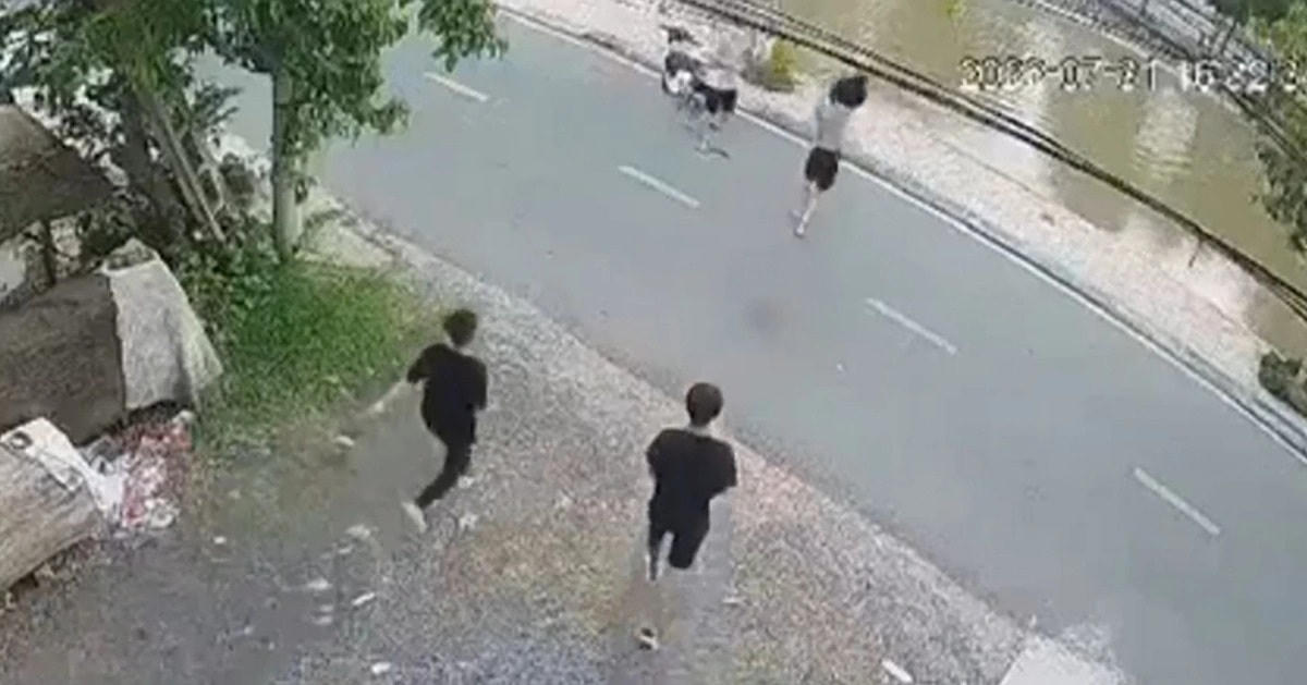 Hình ảnh em An (người chạy trước đang cởi áo) nhảy xuống sông cứu người (Ảnh: Chụp màn hình video).