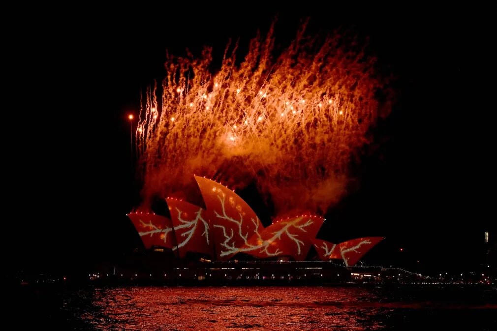 Pháo hoa sặc sỡ giữa nền trời đen kịt, bên trên Nhà hát Opera Sydney được chiếu sáng. Ảnh: Saeed Khan / AFP / Getty Images.