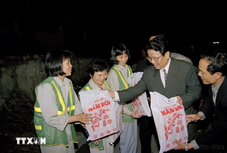 Chủ tịch nước Trần Đức Lương tặng quà và chúc tết công nhân tổ 10 (Công ty Môi trường và đô thị Hà Nội) đang làm nhiệm vụ trong đêm giao thừa Tết Kỷ Mão (1999). (Ảnh: Trọng Nghiệp/TTXVN)