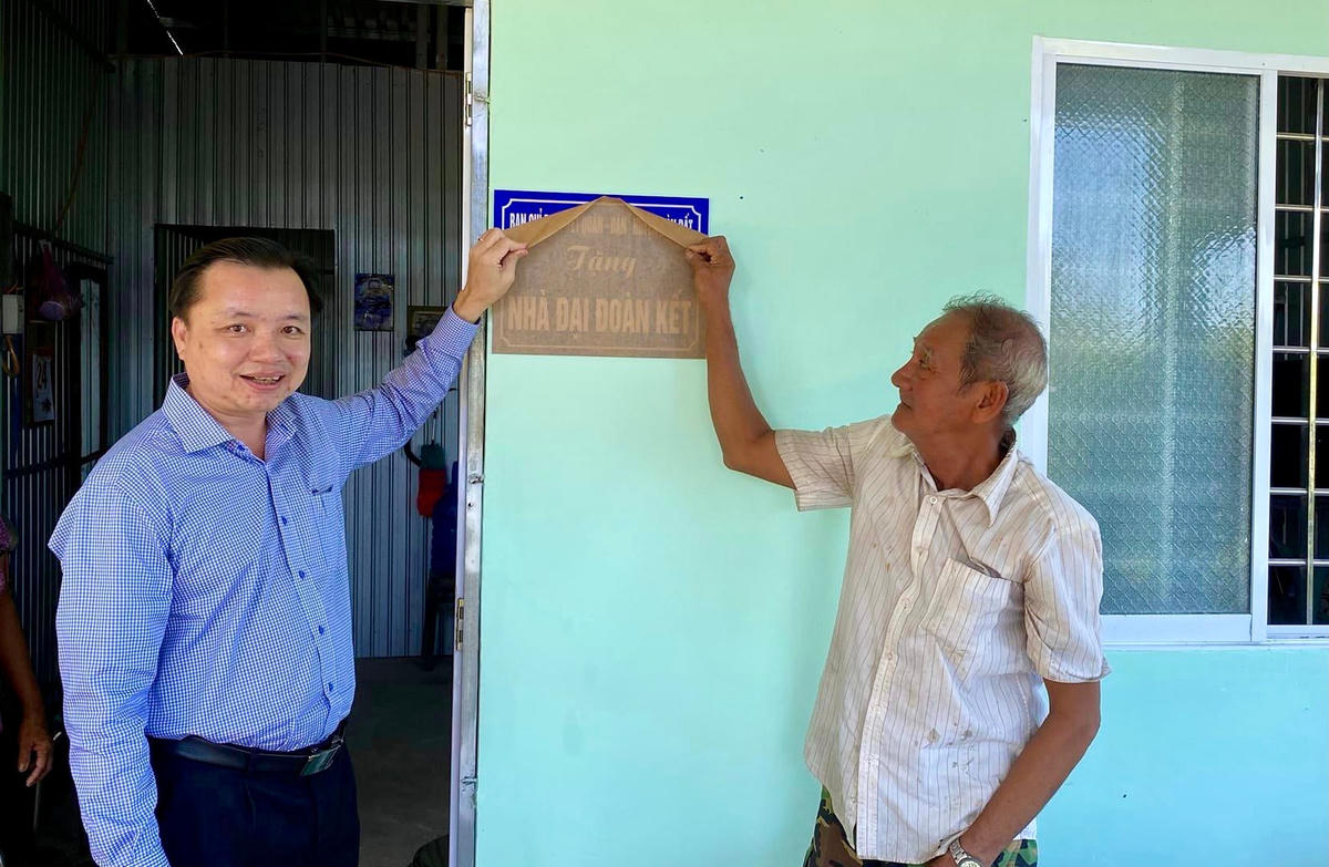 Lãnh đạo huyện Hòn Đất và người dân thực hiện nghi thức bàn giao nhà.