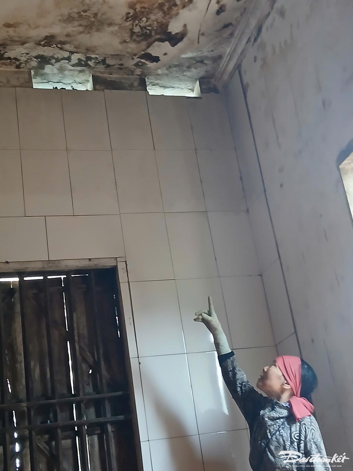 Bà Tình chỉ tay lên góc trần nhà đã bị nứt nhưng không được xây mới.