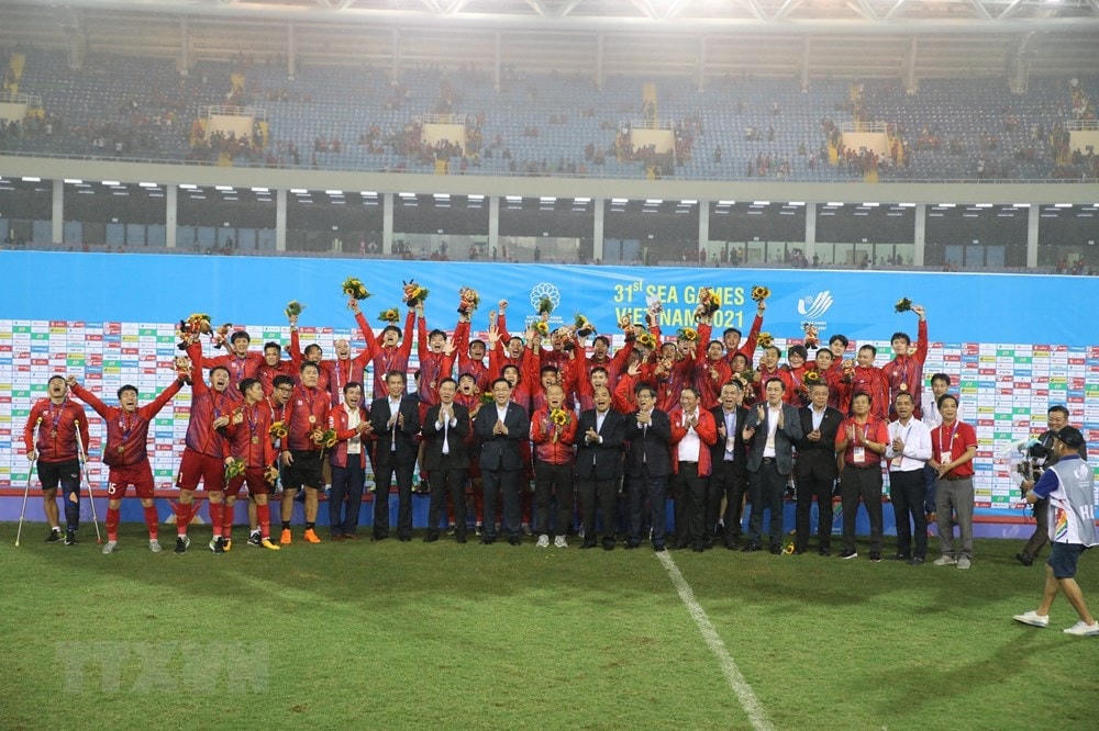 Chủ tịch nước Nguyễn Xuân Phúc, Thủ tướng Phạm Minh Chính, Chủ tịch Quốc hội Vương Đình Huệ, Thường trực Ban Bí thư Võ Văn Thưởng và các đại biểu chụp ảnh chung với Đội tuyển bóng đá U23 Việt Nam vừa giành huy chương Vàng môn bóng đá nam SEA Games 31. Ảnh: TTXVN.