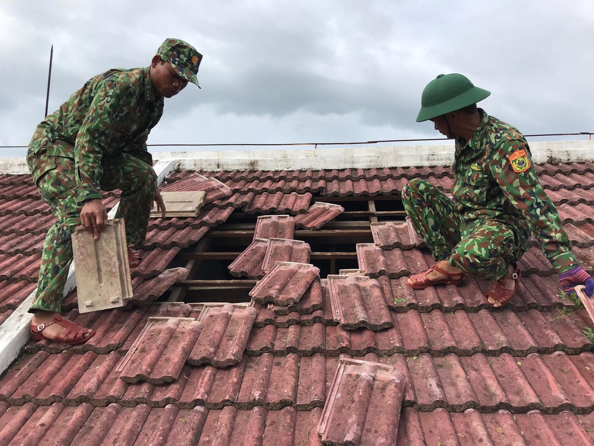 Lực lượng BĐBP tỉnh giúp người dân lợp lại nhà bị tốc mái.