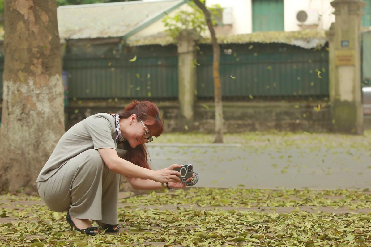 Người dân tranh thủ chụp lại thảm lá vàng dài đến cuối con đường.