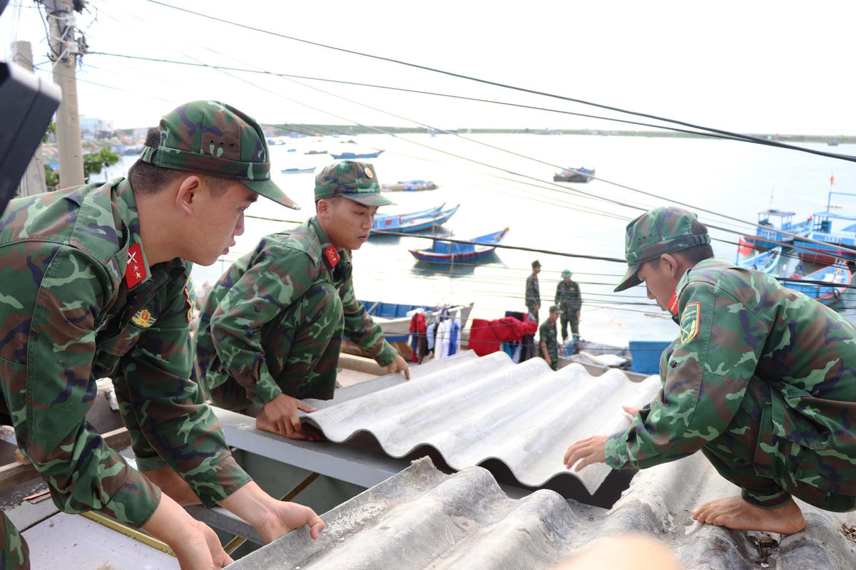 Bộ đội giúp người dân Lý Sơn lợp lại nhà bị tốc mái.