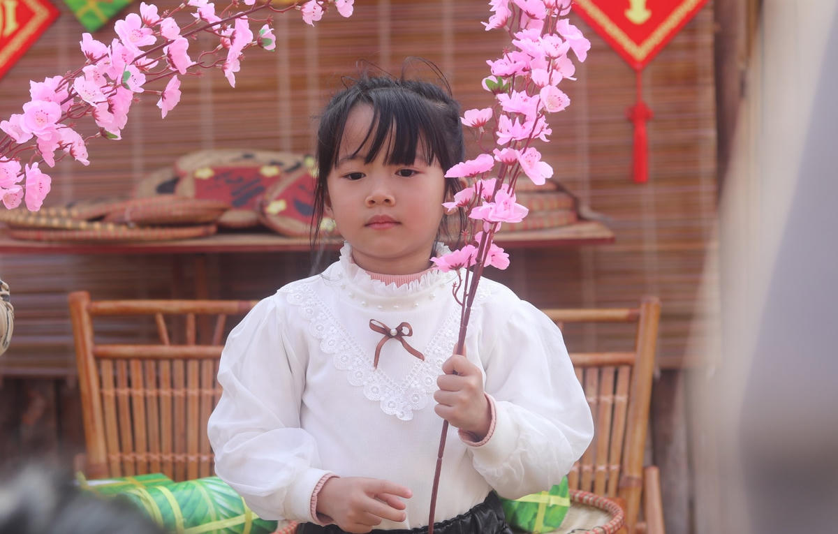 Một bé gái được ba mẹ dẫn đi du xuân tại chùa.