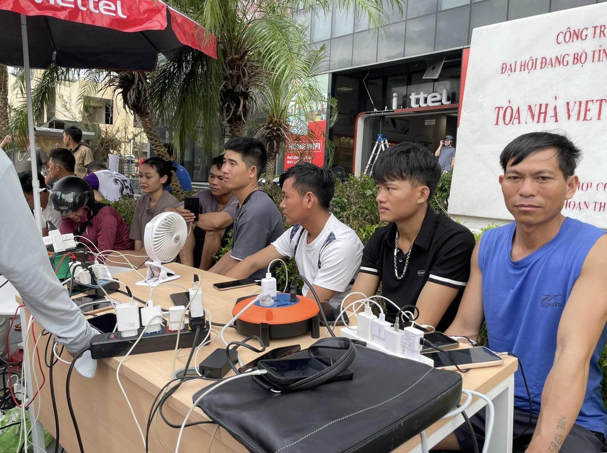 Người dân ra các trạm sạc miễn phí để tranh thủ sạc điện thoại cùng các vật dụng tích điện.