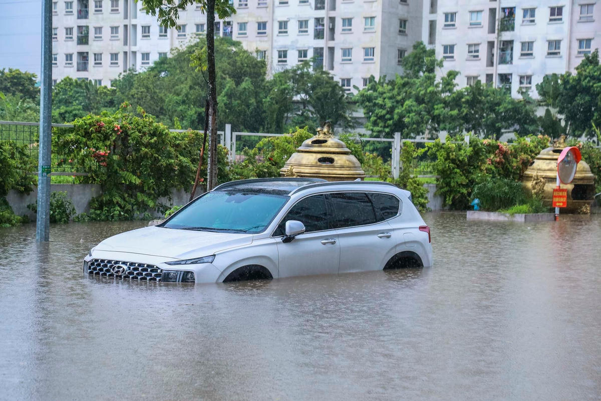Mưa lớn khiến nước dâng cao chiếc ô tô bị ngập nửa thân xe.