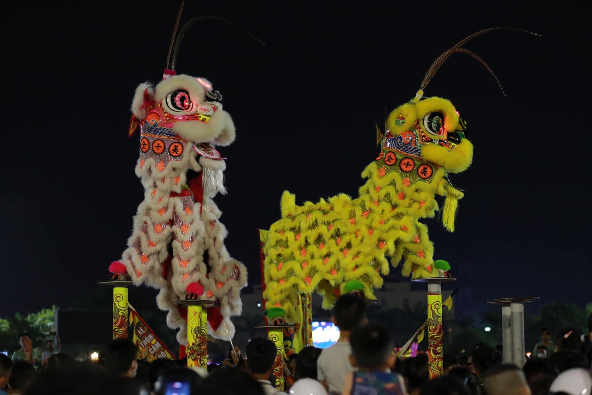 Đội múa lân biểu diễn nhảy trên cột sắt.