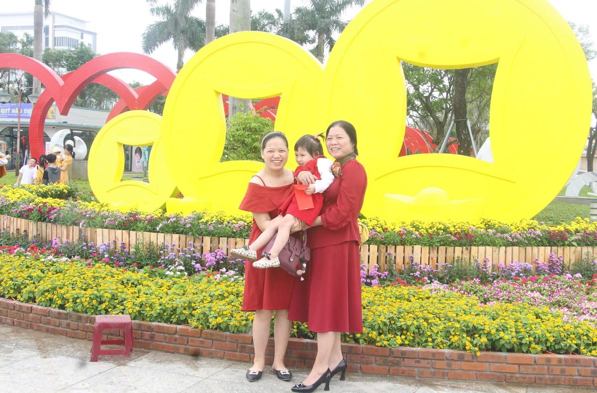 Nhiều người chụp ảnh bên tiểu cảnh tài lộc.