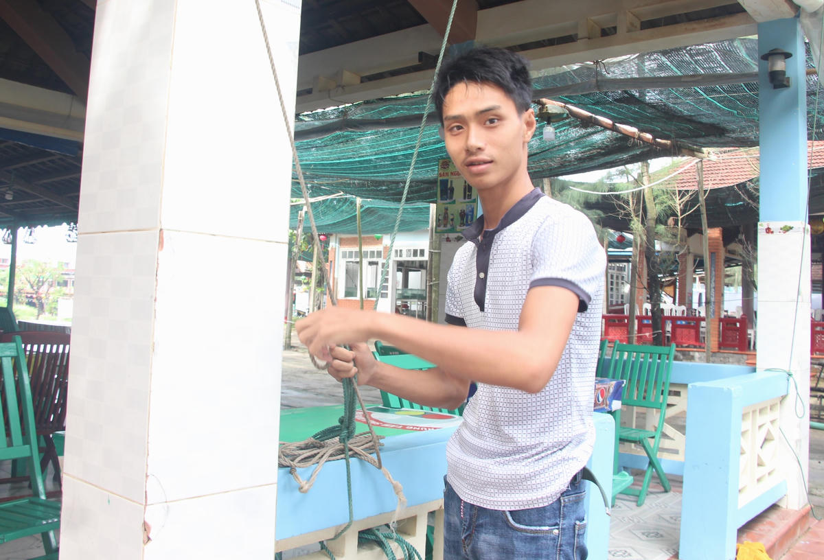 Anh Nguyễn Huy Hoàng cột dây các chòi quán ở biển Cửa Đại.