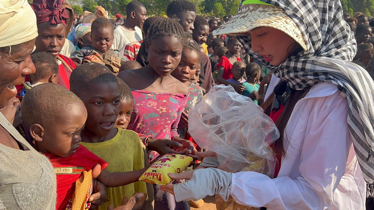 Thùy Tiên phát bánh kẹo cho các em nhỏ sinh sống tại Angola. 