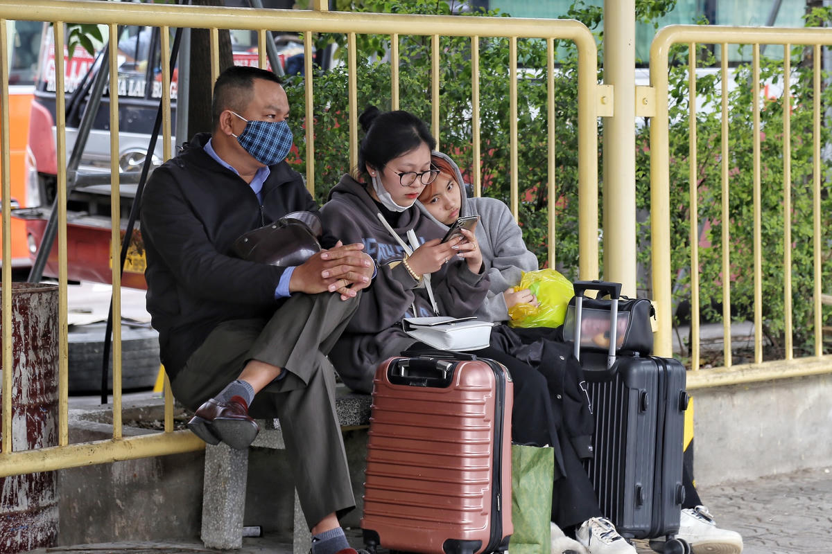 Người dân ngời nghỉ chờ người thân đến đón sau hành trình dài di chuyển từu quê ra Hà Nội.