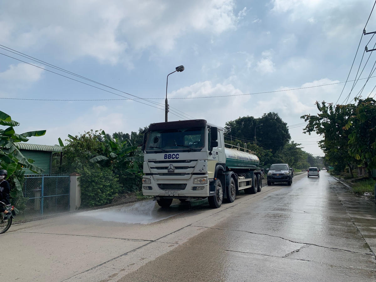 Lâu lâu có một chiếc xe đi rửa đường nhưng cũng không thấm vào đâu so với lượng bụi mà các xe ben chở vật liệu xây dựng tạo nên. Ảnh: Mạnh Thìn.
