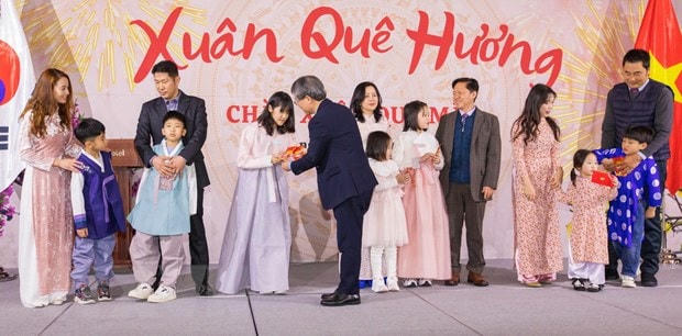 Đại sứ Việt Nam tại Hàn Quốc Nguyễn Vũ Tùng lì xì đầu năm cho trẻ em gia đình đa văn hóa Việt-Hàn tham dự chương trình Xuân Quê hương ngày 8/1/2023. (Ảnh: Anh Nguyên/TTXVN)