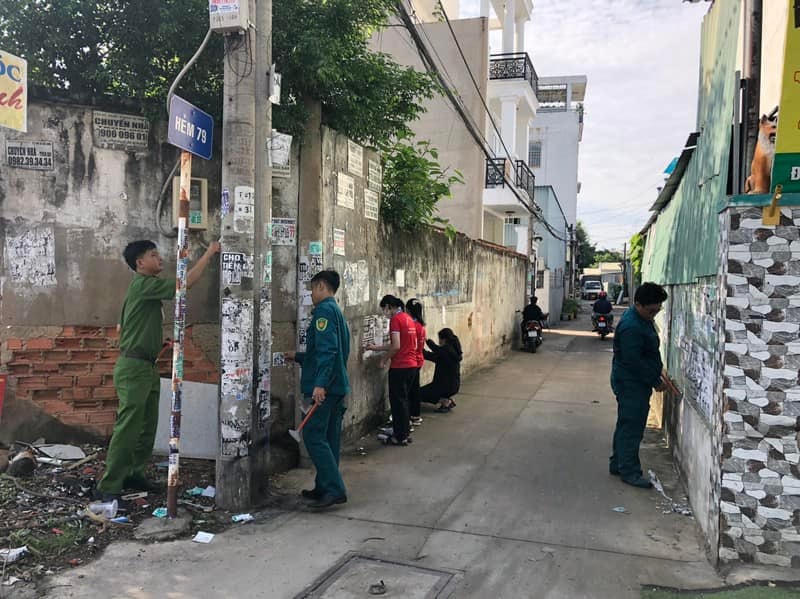 Đông đảo người dân tham gia cùng lực lượng công an và dân quan tự vệ tham gia bóc xóa quảng cáo, tờ rơi trái phép. 