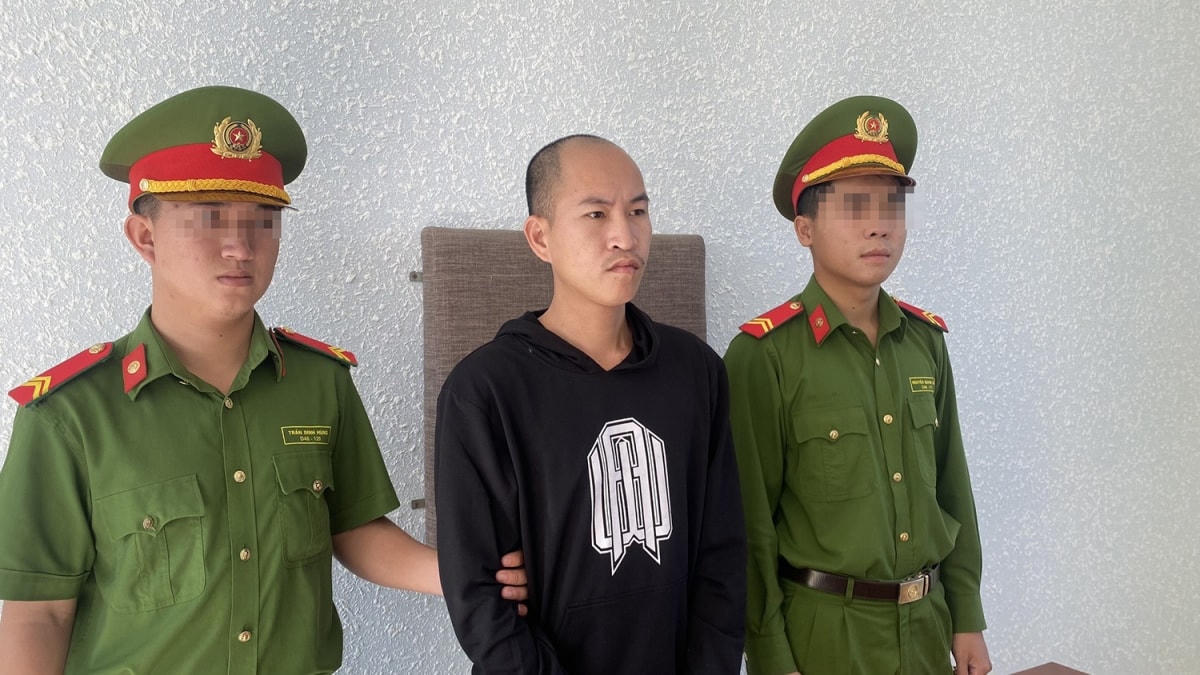 Trương Vạn Nhật nghe công an tống đạt quyết định khởi tố. Ảnh Công an cung cấp.