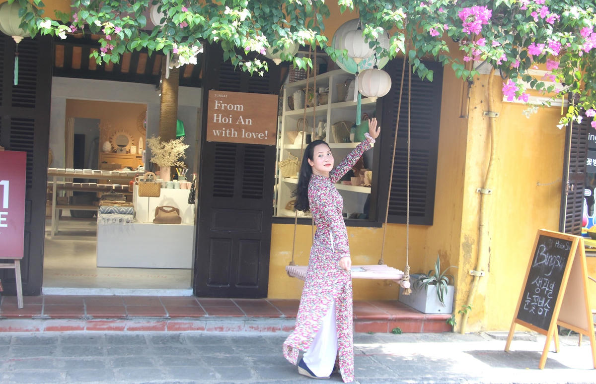 Một bạn trẻ tạo dáng chụp ảnh lưu niệm bên nhà cổ Hội An.