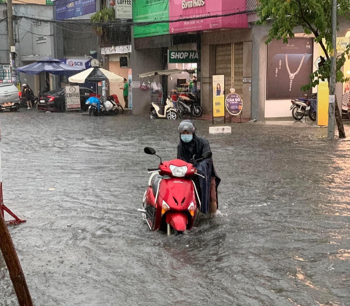 Xe mô tô bị chết máy phải dắt trong nước ngập ở quận 12.