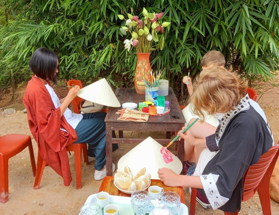 Du khách khi đến tham quan tại nhà anh Nhật sẽ được trải nghiệm tự mình vẽ tranh lên chiếc nón lá.
