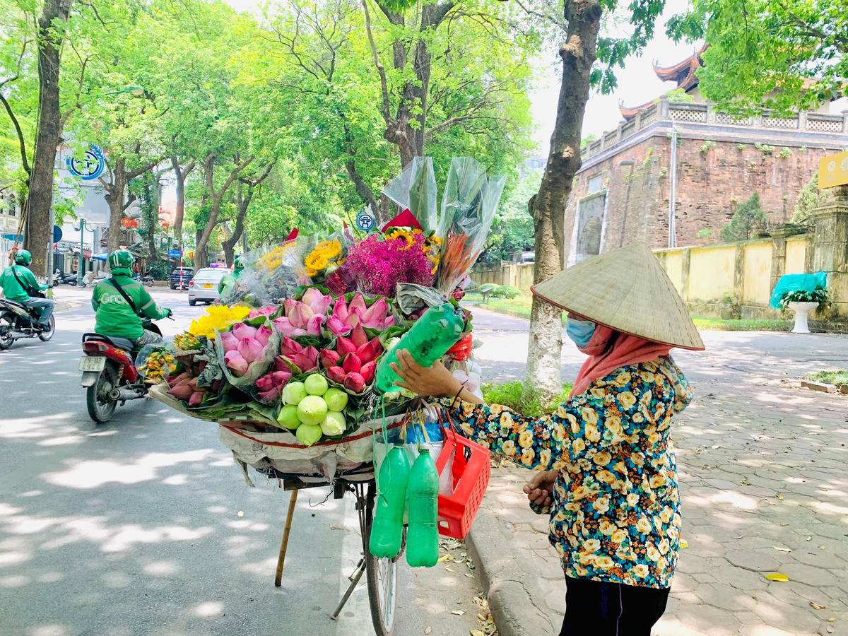 Chị Lan tranh thủ tưới nước cho hoa dưới thời tiết nắng nóng khắc nghiệt.