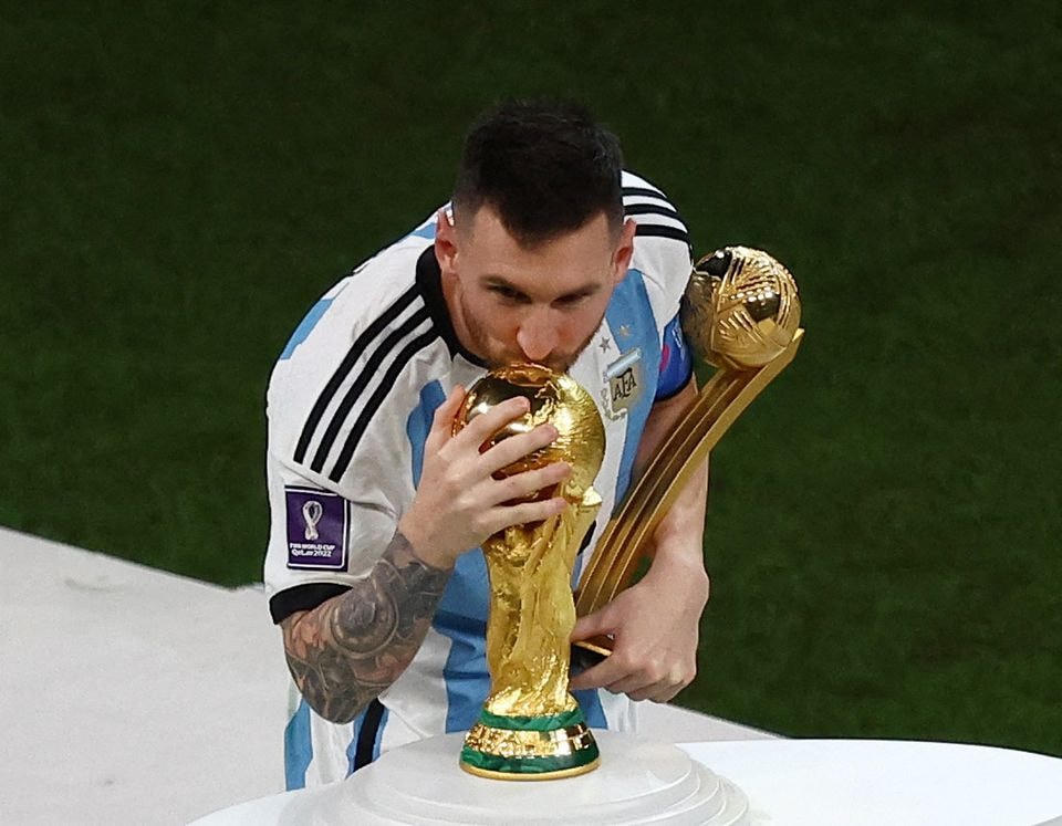 Khoảnh khắc được mong chờ nhất trong cuộc đời của Messi, chạm tay đến chiếc Cup vô địch World Cup. Ảnh: Reuters.
