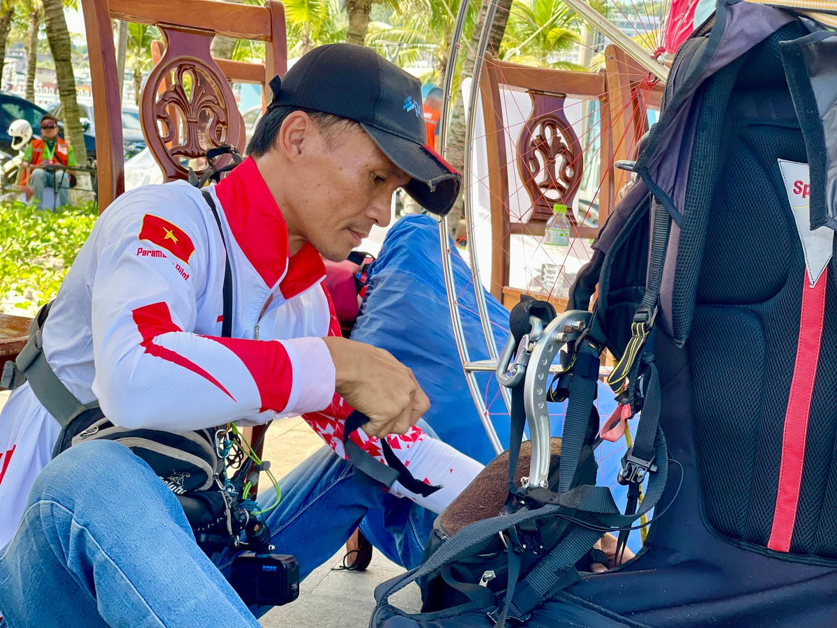 Phi công lắp các thiết bị bảo hộ trên dù lượn.