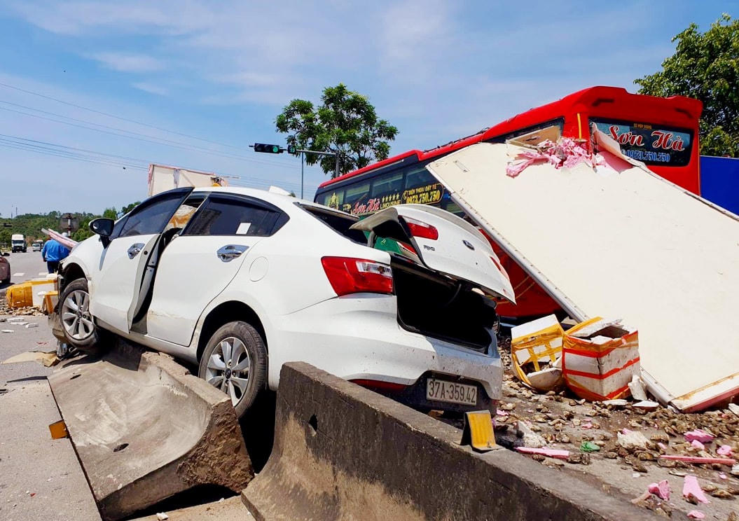 Chiếc xe ô tô con bị đẩy bay lên giải phân cách. 